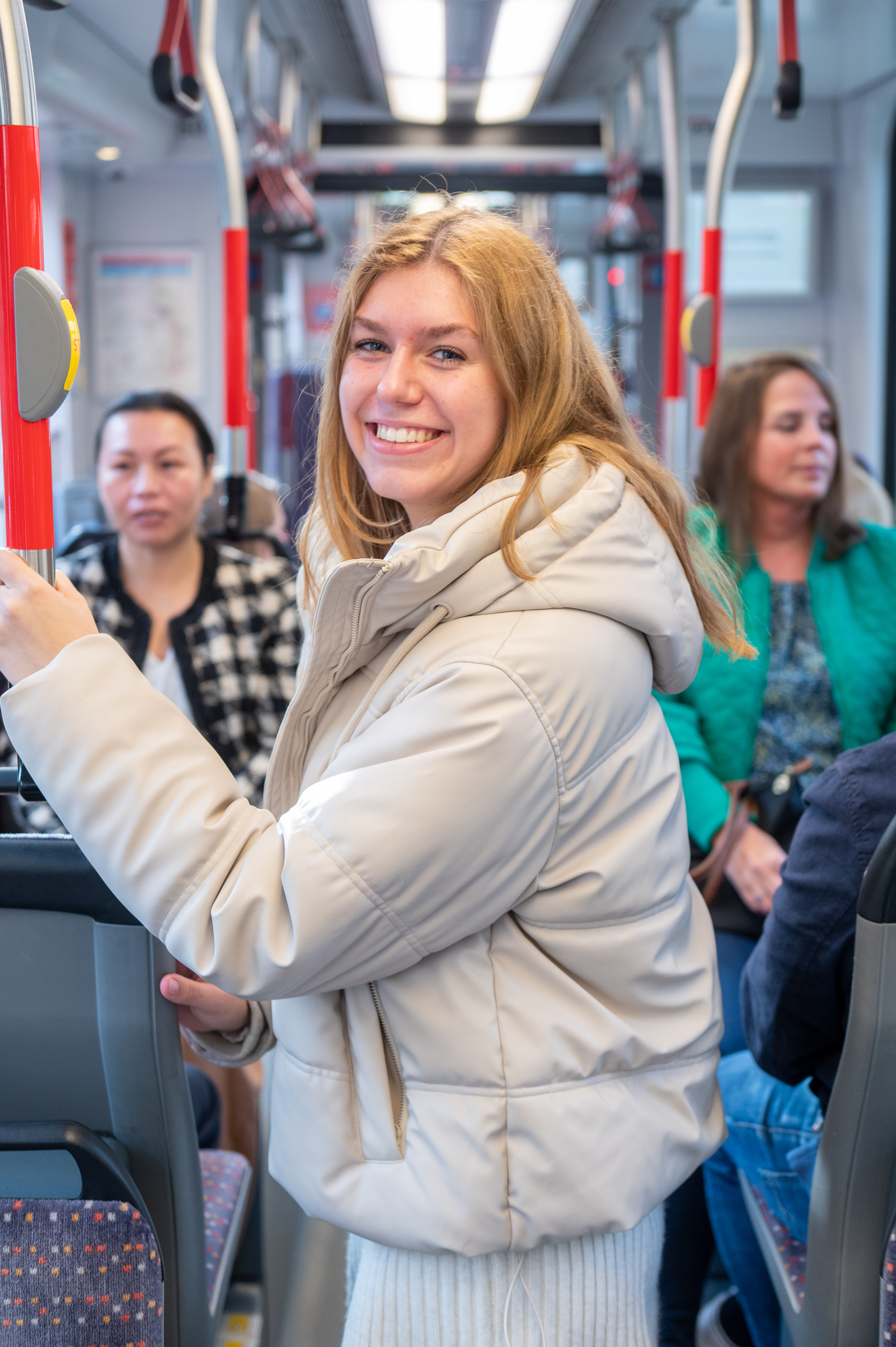 Reiziger staat in HTM tram en lacht naar de camera