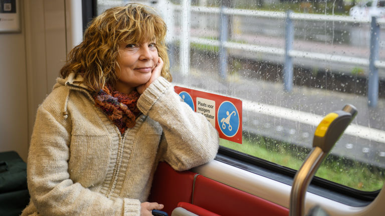 Vrouw zit in tram Vrouw zit in HTM tram en kijkt naar de camera