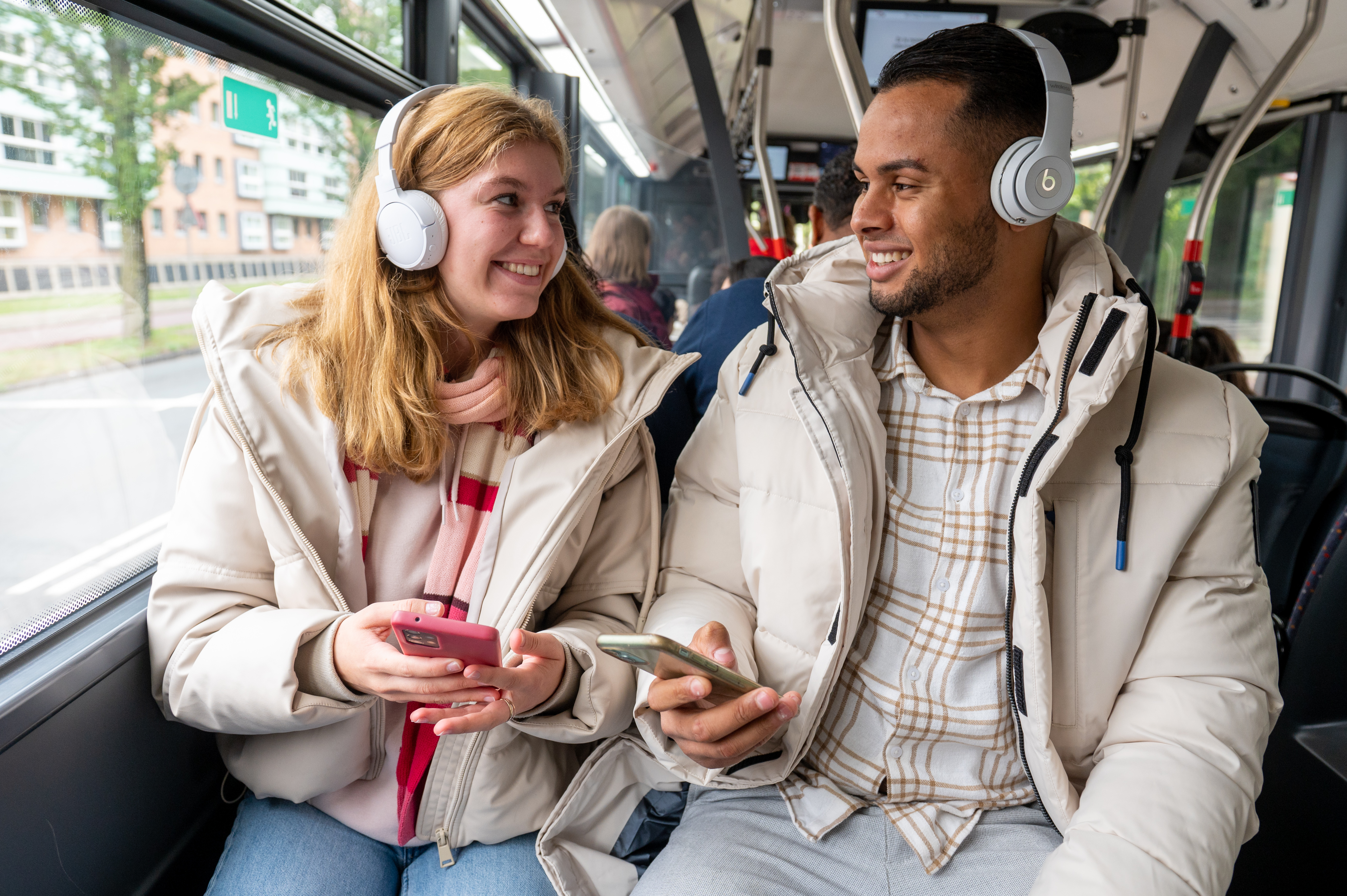 Man en vrouw luisteren samen muziek in HTM bus