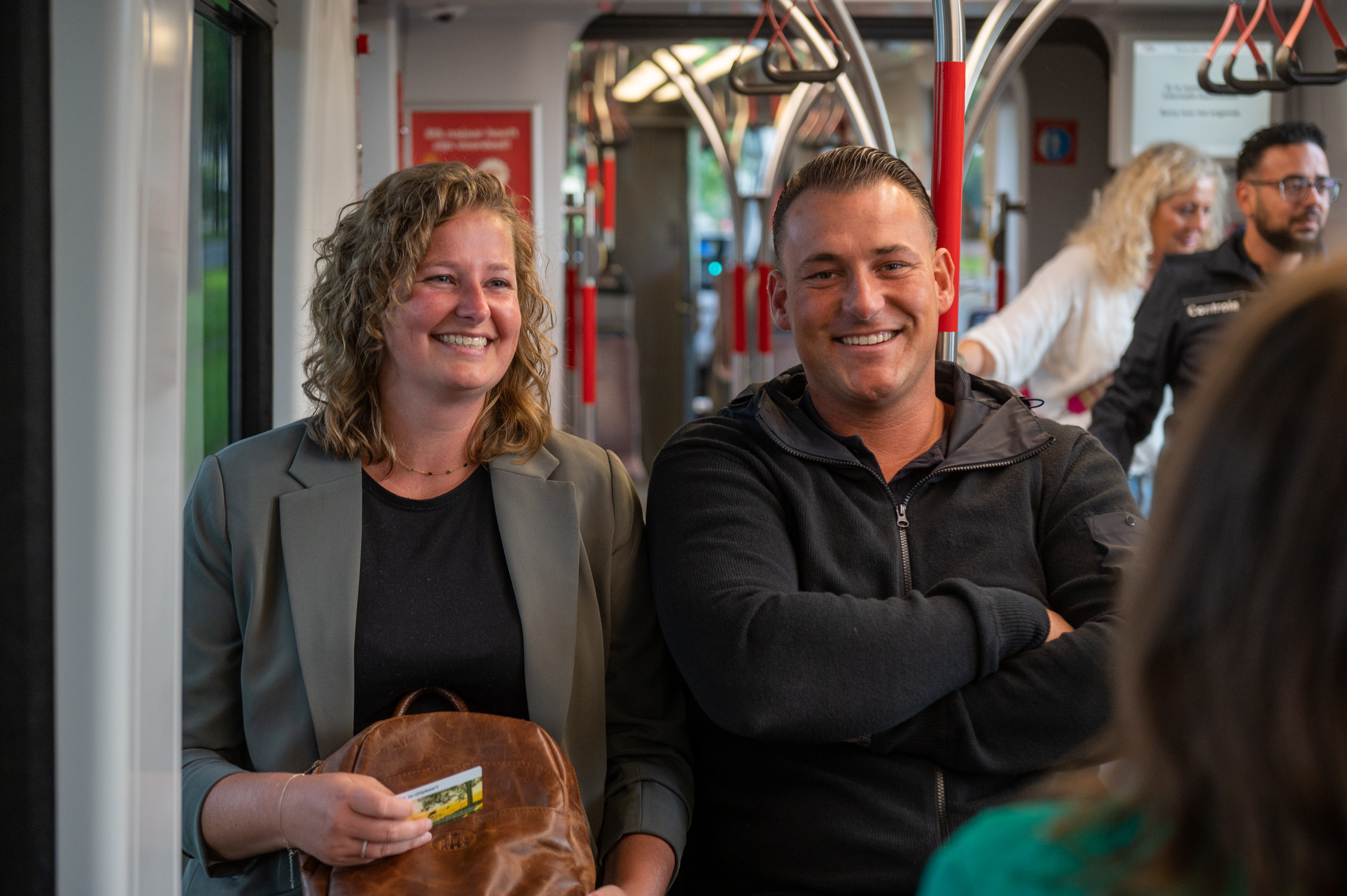 Reizigers zitten in HTM tram en kijken naar de camera