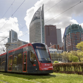Aveniotram grijs-rood met de skyline van Den Haag op de achtergrond Aveniotram grijs-rood met de skyline van Den Haag op de achtergrond