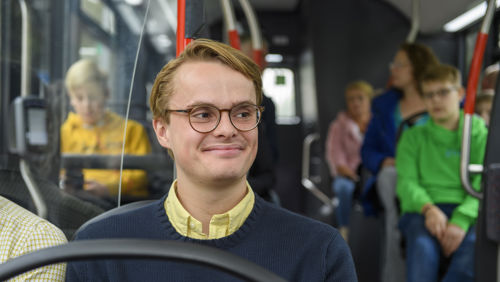 Jongen in bus Jongen in zit HTM bus en kijkt lachend naar voren