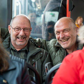 Reizigers zitten in HTM bus Reizigers zitten in HTM bus en lachen naar de camera