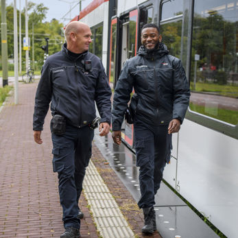 BOA controleurs lopen naast tram HTM BOA controleurs lopen naast HTM tram en lachen naar de camera