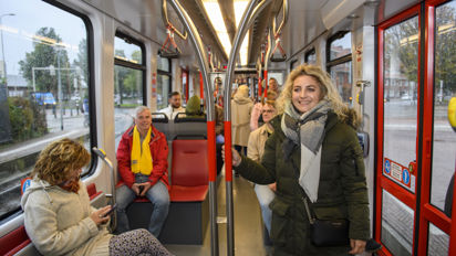 Reizigers in tram Reizigers staan en zitten in HTM tram