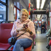 Man en vrouw zitten in de tram Man zit naast vrouw die op de telefoon kijkt in HTM tram