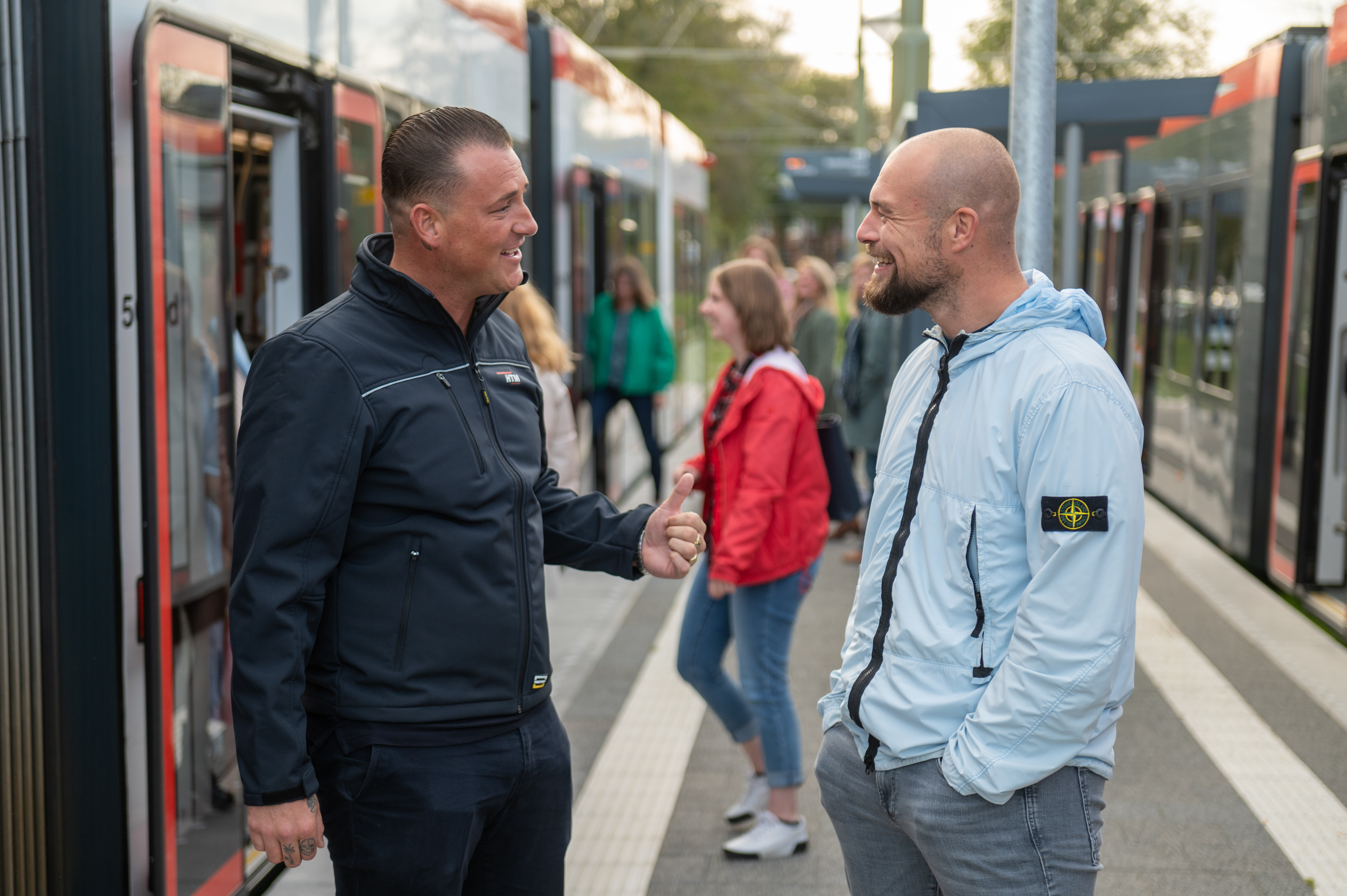 HTM OV steward met reiziger naast HTM tram