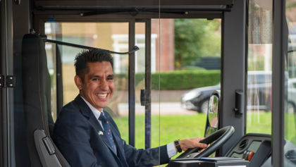 Buschauffeur zit achter het stuur van HTM bus Buschauffeur zit achter het stuur van HTM bus en lacht naar de camera