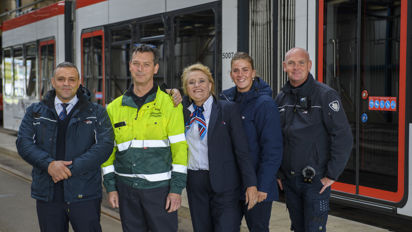 Medewerkers naast tram HTM medewerkers naast HTM tram kijken naar de camera