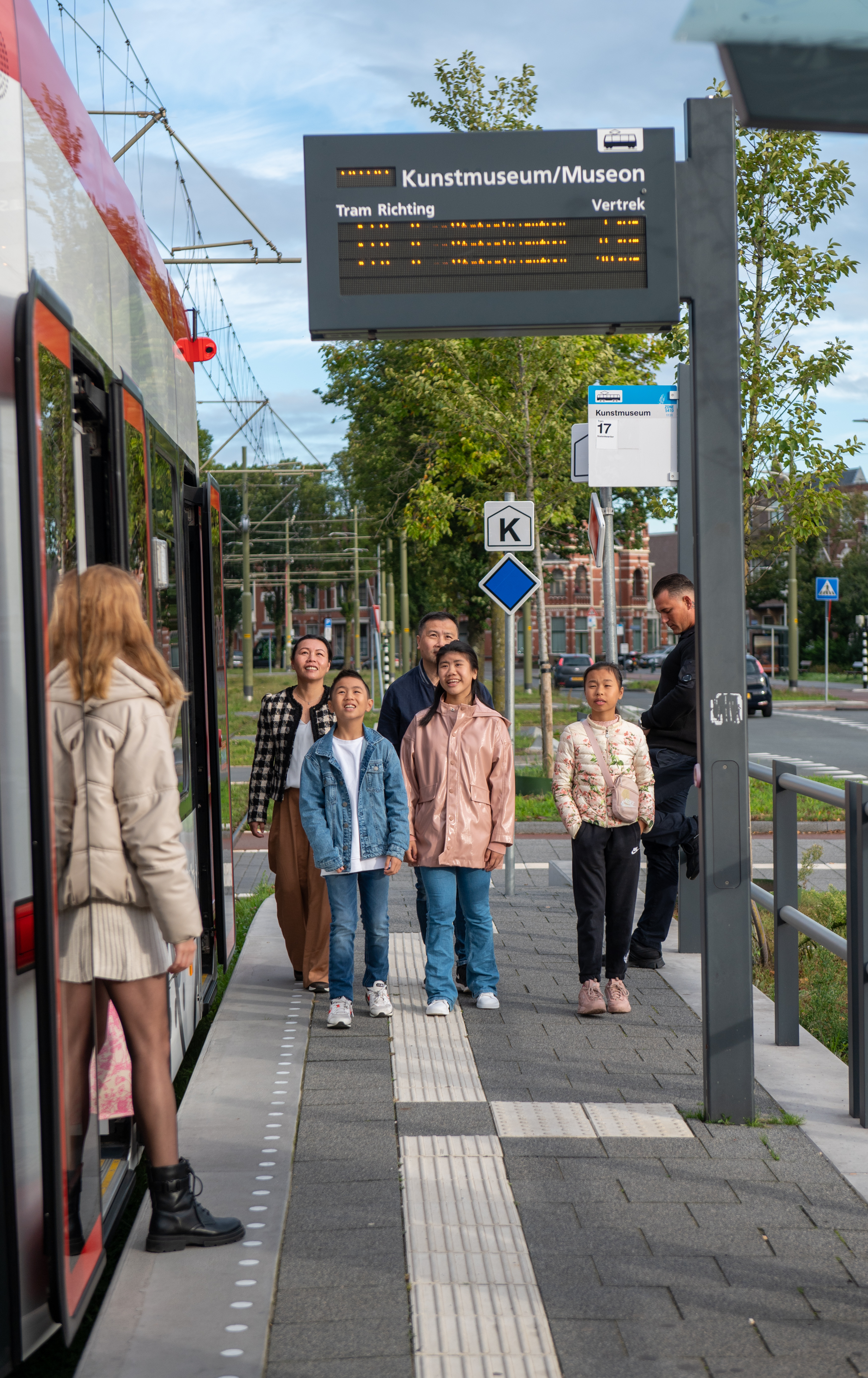 Gezin loopt naast HTM tram