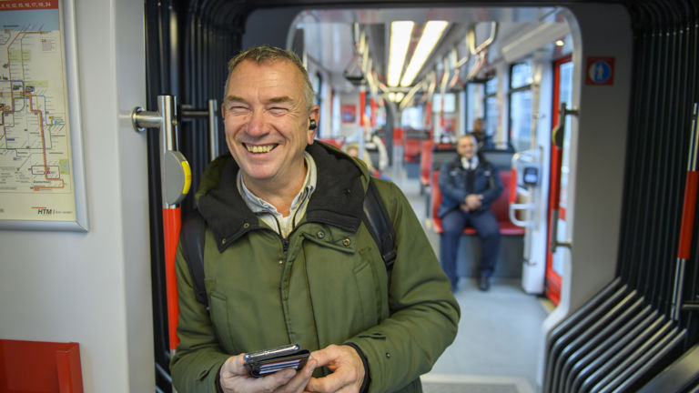 Man staat in tram Man staat in HTM tram en lacht naar de cameras
